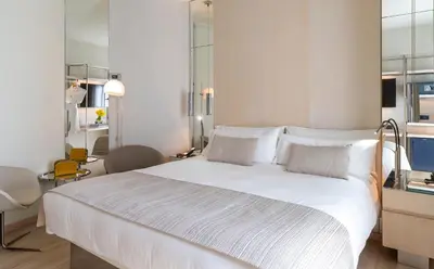 a bedroom with a large white bed with white pillows at Cram Hotel in Barcelona