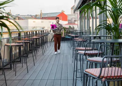 a man walking through a row of tables and chairs at Axel Hotel Barcelona - Adults Only in Barcelona