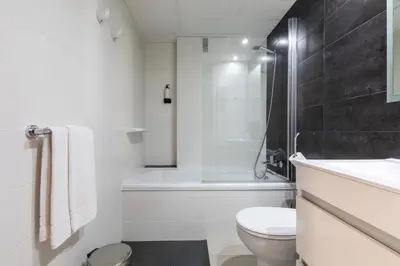 a bathroom with a toilet and a sink and a tub at Aparthotel Miami Park in Calella
