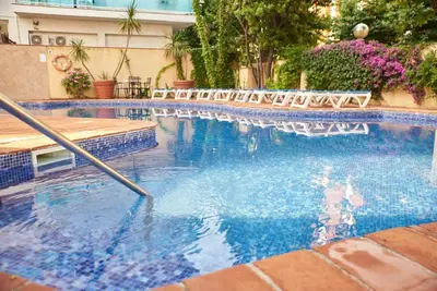 a swimming pool with chairs in a building at DWO Les Palmeres in Calella