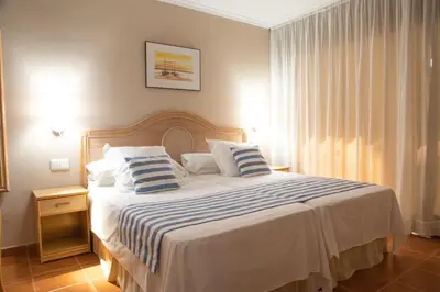 a bedroom with a large bed with blue and white pillows at DWO Les Palmeres in Calella