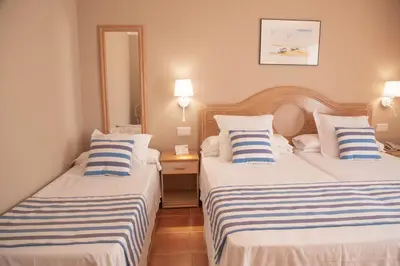 a hotel room with two beds with striped pillows at DWO Les Palmeres in Calella