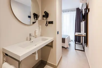 a bathroom with a sink and a mirror at DWO Les Palmeres in Calella