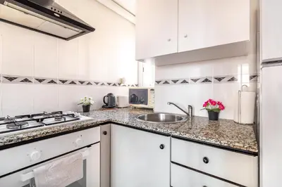 a kitchen with white cabinets and a sink at Dream House in Badalona
