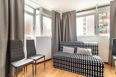 a bedroom with a bed and two chairs at Dream House in Badalona