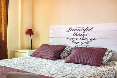 a bed with two pillows and a sign on the wall at Dream House in Badalona