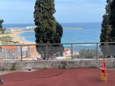 a red fire hydrant in front of a view of the ocean at 3 BDRM APART NEAR THE SEA! GREAT FOR KIDS! in Arenys de Mar