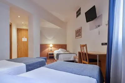a hotel room with two beds and a table at Acta Antibes in Barcelona