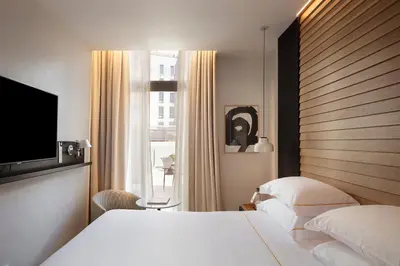 a hotel room with two beds and a flat screen tv at Casa Elliot Hotel in Barcelona