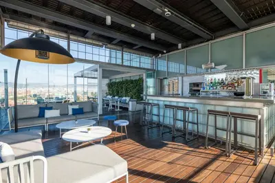 a restaurant with a bar with a view at Leonardo Royal Hotel Barcelona Forum in Barcelona
