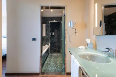 a bathroom with a shower and a sink and a tub at Leonardo Royal Hotel Barcelona Forum in Barcelona