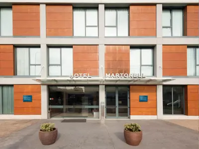 a building with two potted plants in front of it at Hotel Ciutat Martorell in Martorell
