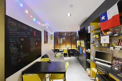 a dining room with a table and yellow chairs at Free Hostels Barcelona in Barcelona