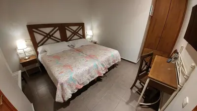 a small bedroom with a bed and a table at La Ciudadela in Barcelona