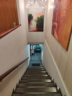 a staircase in a hallway with paintings on the wall at La Ciudadela in Barcelona