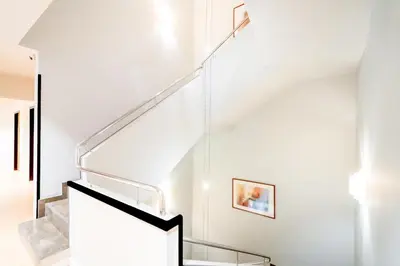 a white staircase with glass railings in a house at Hotel Glòries in Barcelona