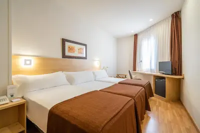a hotel room with a large bed and a television at Hotel Glòries in Barcelona