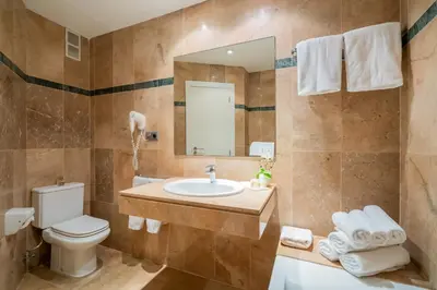 a bathroom with a sink and a toilet and a mirror at Hotel Glòries in Barcelona