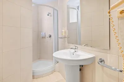 a white bathroom with a sink and a shower at B&B HOTEL Barcelona Mollet Porta de Gallecs in Mollet del Vallès