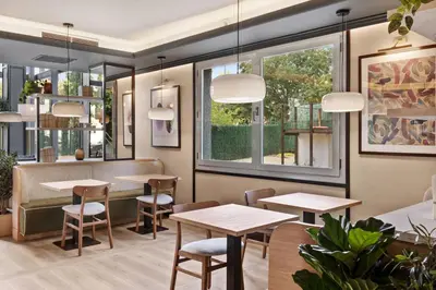 a restaurant with tables and chairs and windows at B&B HOTEL Barcelona Mollet Porta de Gallecs in Mollet del Vallès
