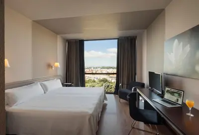 a hotel room with a bed and a desk and a window at Ciutat de Granollers in Granollers