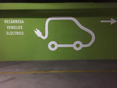 a sign on a green wall with an electric car at Ciutat de Granollers in Granollers
