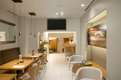 a restaurant with tables and chairs and a tv on the wall at Best Western Premier Hotel Dante in Barcelona