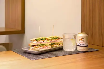 a sandwich on a table next to a glass of water at Best Western Premier Hotel Dante in Barcelona