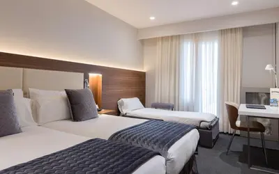 a hotel room with two beds and a desk at Best Western Premier Hotel Dante in Barcelona