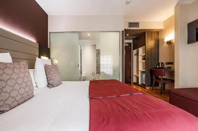 a bedroom with a large bed with a red blanket at Hotel Ronda Lesseps in Barcelona