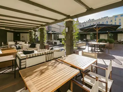 a patio with tables and chairs on a roof at Hotel Granvia in Barcelona