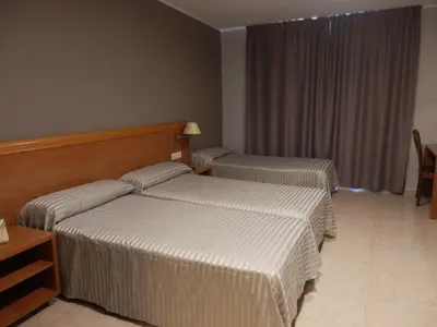 a hotel room with two beds and a window at Hotel Inglés in Barcelona
