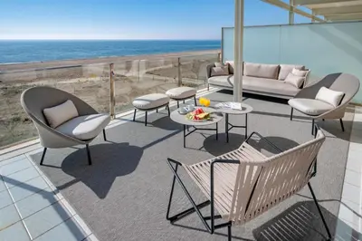 a patio with chairs and a couch and the ocean at Bel Air in Castelldefels
