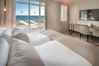 a hotel room with a bed and a view of the ocean at Bel Air in Castelldefels