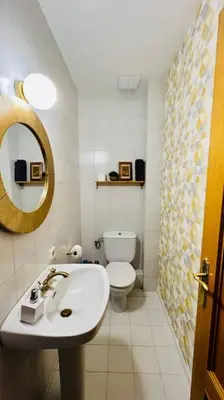 a bathroom with a sink and a toilet and a mirror at Mediterranean house, beach and charm garden in Arenys de Mar