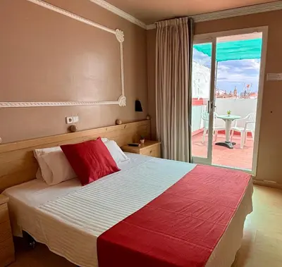 a bedroom with a bed with a view of a balcony at Hotel Piccadilly Sitges in Sitges