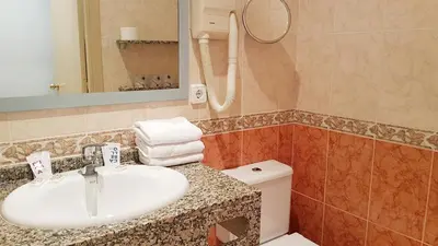 a bathroom with a sink and a toilet at Hotel Piccadilly Sitges in Sitges