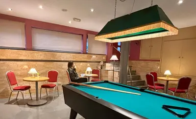 a woman sitting at a pool table in a restaurant at Hotel Piccadilly Sitges in Sitges