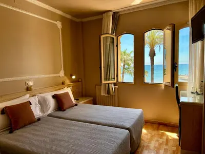 a bedroom with a bed with a view of the ocean at Hotel Celimar in Sitges