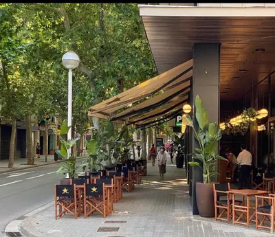 a row of tables and chairs on a city street at Hotel Urpí in Sabadell