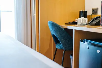 a hotel room with a blue chair at a desk at Abba Rambla Hotel in Barcelona