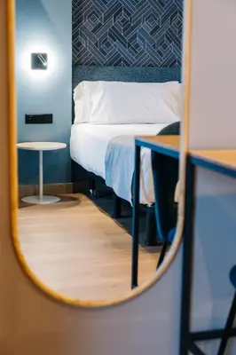 a bedroom with a bed and a mirror at Abba Rambla Hotel in Barcelona