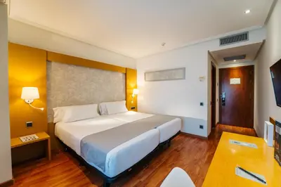 a bedroom with a large bed and a television at Abba Rambla Hotel in Barcelona