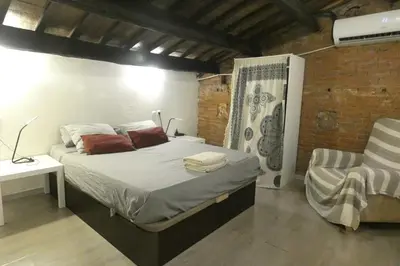 a bedroom with a bed and a chair at Charming house next to the sea and Barcelona for 6 in Badalona