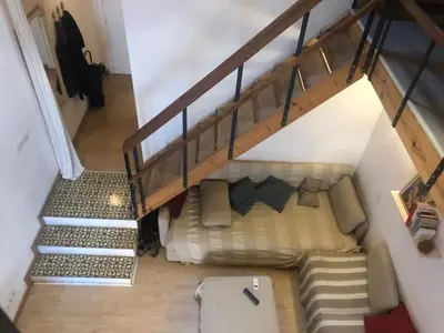 a room with a bed under a stair case at Charming house next to the sea and Barcelona for 6 in Badalona