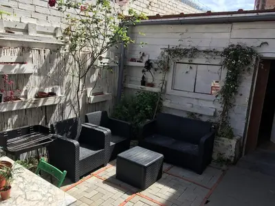 a patio with two chairs and a bench and a building at Charming house next to the sea and Barcelona for 6 in Badalona