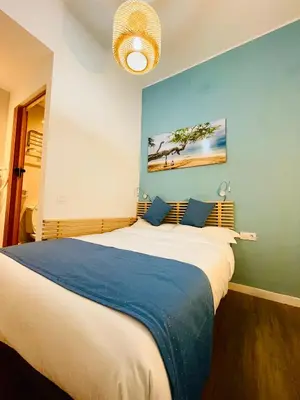 a bedroom with a large bed with a blue wall at Pensión Bertolín in Barcelona