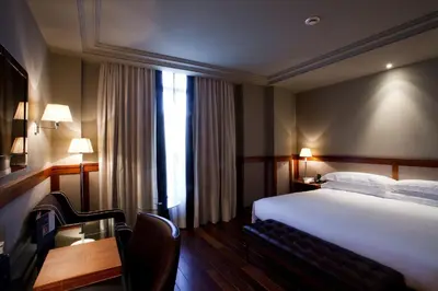 a hotel room with a bed and a desk and a table at Hotel 1898 in Barcelona