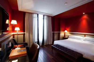 a hotel room with a bed and a table and chairs at Hotel 1898 in Barcelona