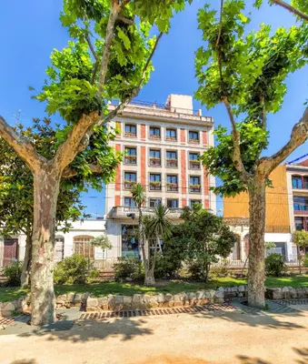 a building with trees in front of it at Espanya - 30º hotels in Calella